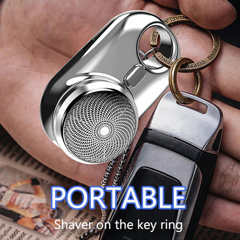 Portable shaver on a key ring held in a hand with visible text.